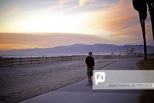 Mann fährt Skateboard auf der Promenade in der Nähe des Strandes  Santa Monica  Kalifornien  Vereinigte Staaten