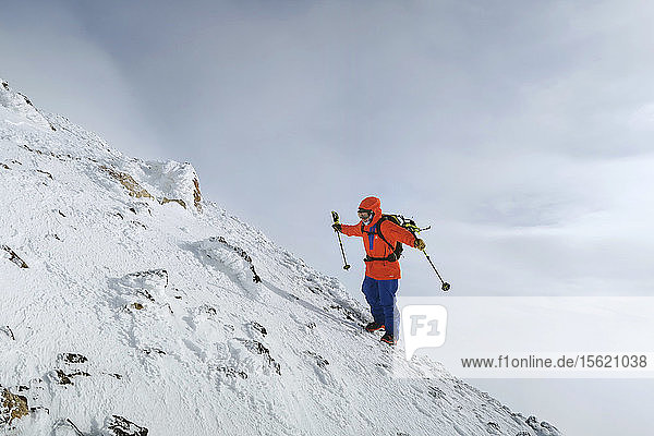 Ein Mann hängt gegen den Wind während einer Skitour in den Bergen von Hokkaido