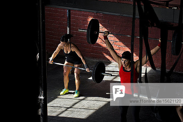 Zwei Frauen trainieren in einem Crossfit-Fitnessstudio.