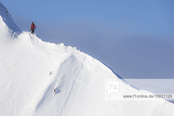 Die professionelle Snowboarderin Marie France Roy geht an einem sonnigen Tag in Haines  Alaska  an einer Kammlinie entlang  um zu ihrer Line zu gelangen.