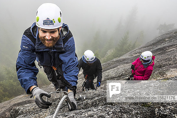 Ein Mann greift beim Besteigen des Klettersteigs in Squamish  British Columbia  nach der Metallsprosse.