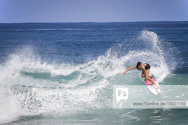 Full length shot of single woman surfing in sea