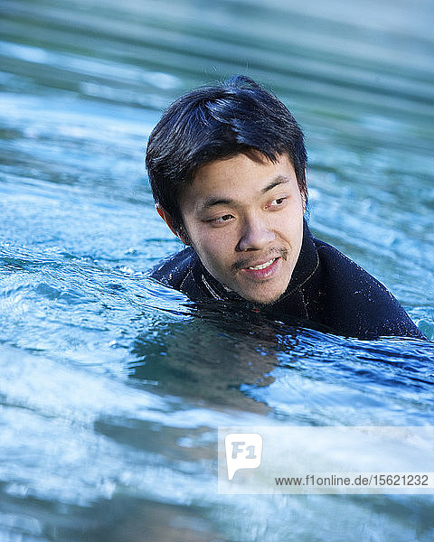Ein junger asiatischer Mann im Wasser.