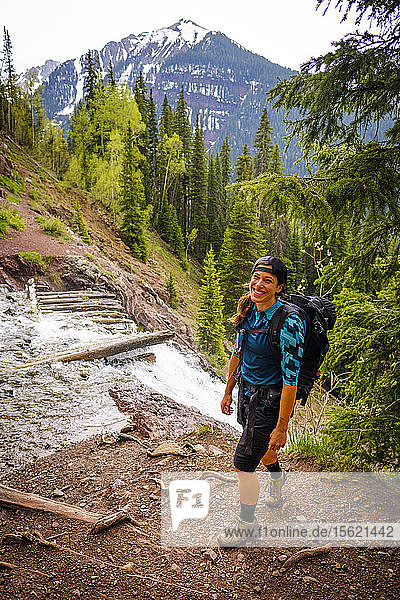 Woman hiker in scenic landscape stopping to take in the sights on the Ice Lakes trail  USA