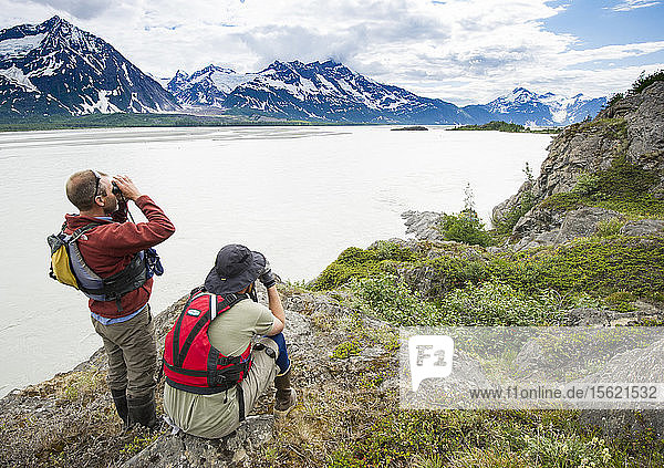 Rafters Looking Through The Binocular Over The Bank Of Alsek River