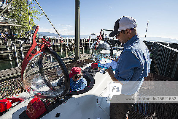 Men preparing prototype personal two-man submarine for test dive  Homewood Marina  Lake Tahoe  California  USA