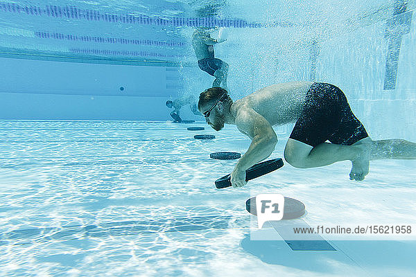 Unterwasseransicht eines Sportlers  der ein Gewicht im Schwimmbad trägt  Teneriffa  Kanarische Inseln  Spanien