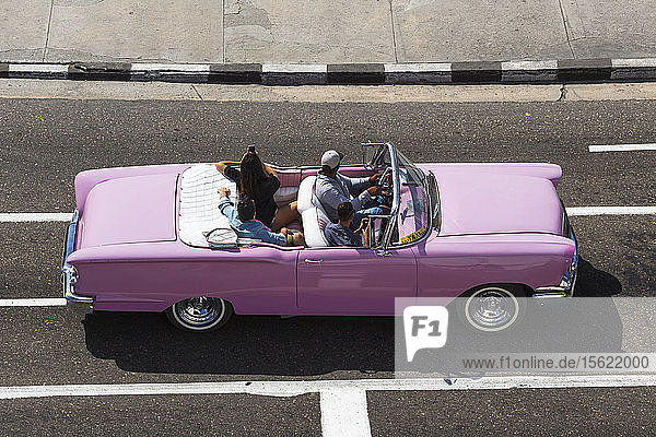 Rosa Cabriolet amerikanischer Oldtimer mit kubanischem Fahrer und Touristen  Havanna  Kuba