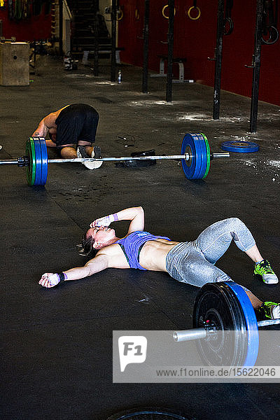 Zwei Crossfit-Sportler liegen nach einem intensiven Training in einem Fitnessstudio in San Diego  Kalifornien  schmerzhaft auf dem Boden.