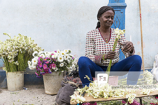 Eine Frau stellt ein Blumenarrangement in den Straßen von Havanna  Kuba  zusammen