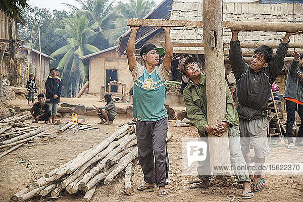 Männer justieren die Position der Stelzen für ein neues Haus  das in Ban Pak Luang  Laos  gebaut wird. Die erhöhten Stelzen schützen vor Schlamm und Überschwemmungen in der Regenzeit. Das Dorf würde durch den geplanten Staudamm Nr. 3 (mit dessen Bau noch nicht begonnen wurde) nur geringfügig überflutet werden.