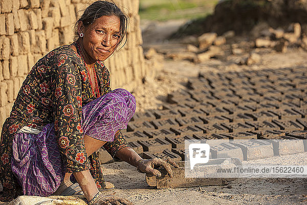 Herstellung von Lehm für den Wiederaufbau von Häusern. Dorf Lele  16 km von Patan entfernt. Nepal. Die Tränen sind getrocknet. Keine Zeit zum Trauern oder Warten auf die Hilfe. Die Menschen in Lele bauen in Selbsthilfe eine Unterkunft aus den Überresten ihres zerstörten Hauses. Das Erdbeben hat ihnen zwar ihre Häuser genommen  aber nicht die Hoffnung auf ein neues Leben  die sie hatten.