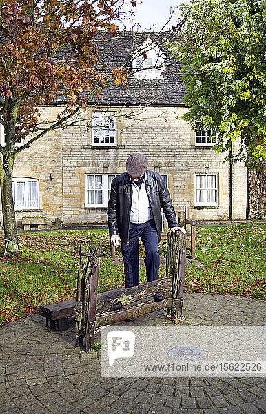 Ein Besucher probiert den alten Stock von Stow-on-the-wold an