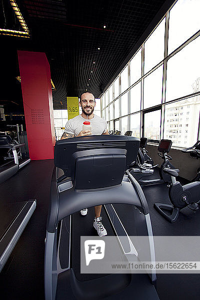 Muskulöser Mann läuft auf einem Laufband in einem Fitnessclub  Sport im Fitnessclub