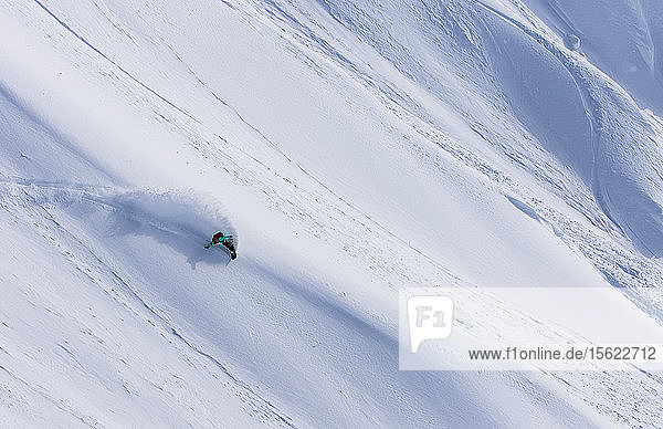 Der Profi-Snowboarder und Olympiasieger von 2014  Jamie Anderson  fährt an einem sonnigen Tag beim Snowboarden in Haines  Alaska  durch frischen Powder.