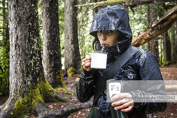 Frau trinkt Yerba Matte im Wald