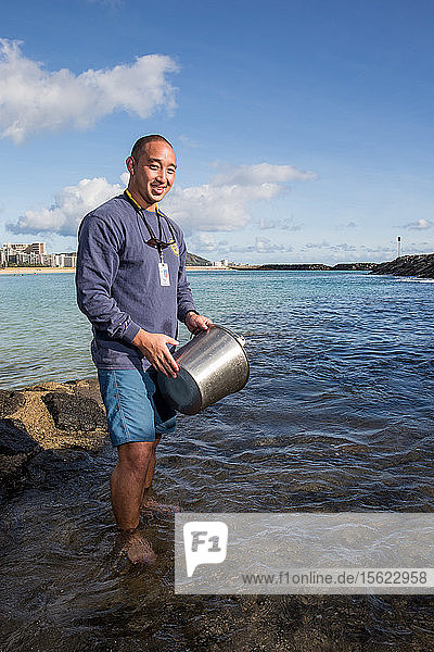 Wataru Kumagai of the State of Hawaii Department of Health Clean Water Branch  demonstrates water sampling of Hawaiian beaches at Ala Moana Beach in Honolulu using instruments such as a turbidity meter. For the full scope of readings  lab work has be done offsite.