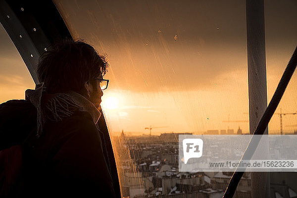 Mann schaut bei Sonnenuntergang durch ein Fenster auf Paris  Frankreich  im Centre Georges Pompidou
