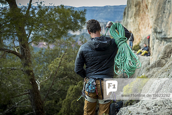 Rückansicht eines männlichen Bergsteigers  der ein Seil zum Felsen trägt  Siurana  Katalonien  Spanien