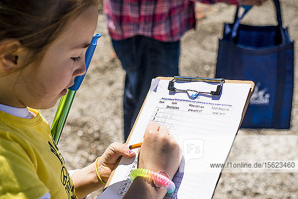 Junge Freiwillige  die bei der Strandsäuberung zum Tag der Erde in ein Klemmbrett schreiben  Portsmouth  Rhode Island  USA