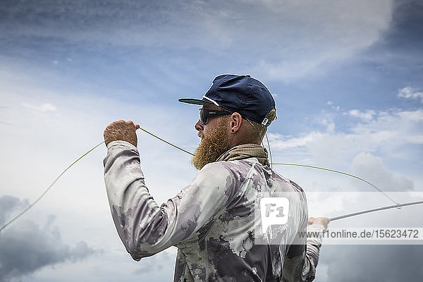 Angler Jonathan Jones casts while fishing in the tropics of Samoa.
