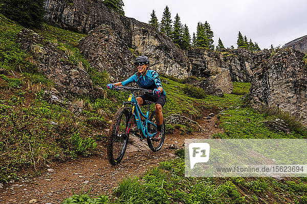 Woman mountain biker in rocky landscape rides downhill on the Ice Lakes trail  USA