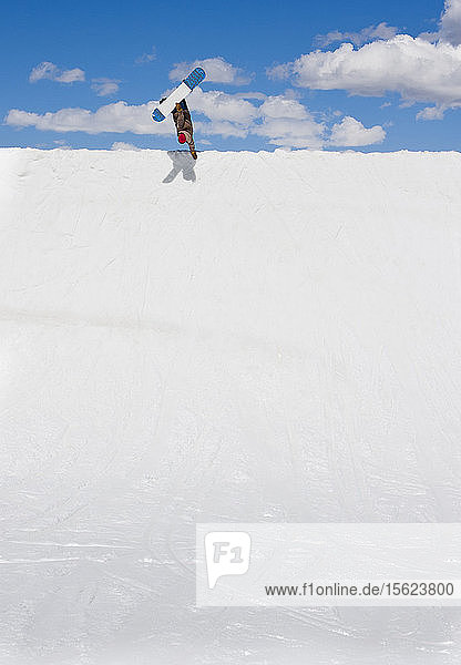 A man does a handplant on his snowboard at Breckenridge  Colorado.