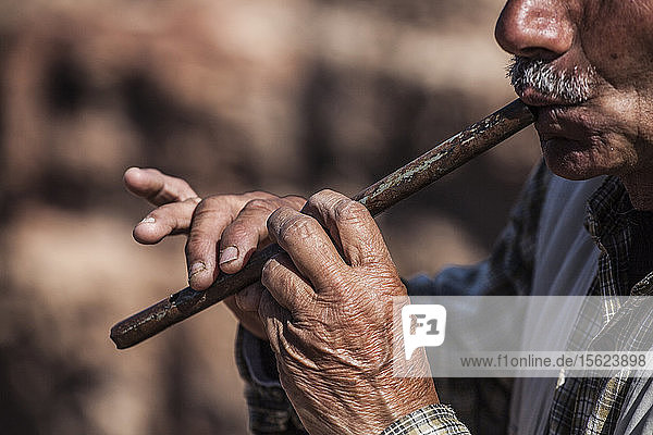 Ein Beduine spielt in Petra  Jordanien  auf einer Flöte.