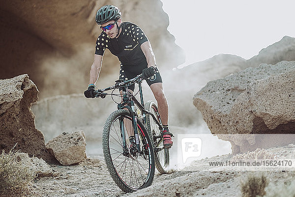 Man rides his mountain bike in desert  Tenerife  Canary Islands  Spain