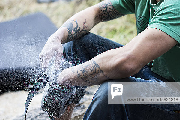 A Male Climber Chalks Up His Hands As He Prepares For A Climbing In Chihuahua