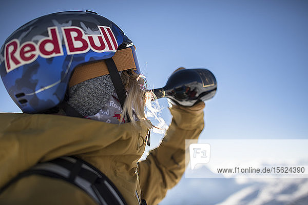 Skifahrer in Skikleidung  der Wein aus einer Flasche trinkt  Monterosa Ski Mountain Resort in Gressoney  Aosta  Italien