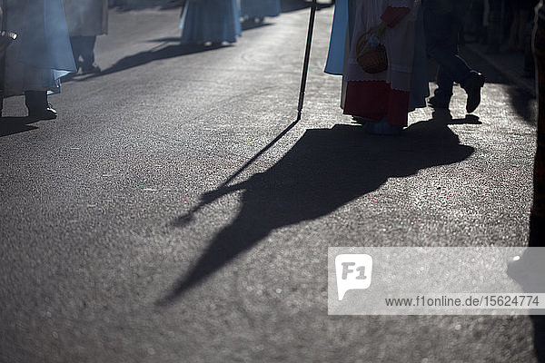 Die Silhouette eines vermummten Büßers  der einen Stab hält  bei der Prozession am Palmsonntag während der Osterwoche in Prado del Rey  Naturpark Sierra de Grazalema  Provinz Cádiz  Andalusien  Spanien