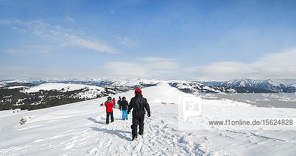 Group Of People Hike Down A Snow Covered Mountain To Snowmobiles  Vail  Colorado