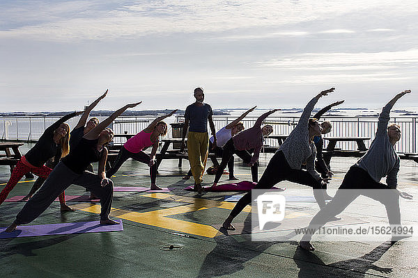 Early morning with a yoga course by the yoga instructor Anandh Pillay perched on the heliport at the Viking Line ferry in the Stockhlm archipelago Baltic sea.
