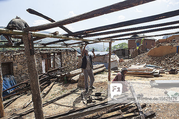 Die Häuser sind eingestürzt  aber die Menschen stehen aufrecht. Die Tamang-Gemeinschaft des Dorfes Lele hilft einander beim Wiederaufbau der Häuser und bei der Wiederherstellung des Lebens  das sie durch das grausame Erdbeben vom 25. April 2015 verloren hat. Das Dorf Lele  16 km von Patan entfernt. Nepal.