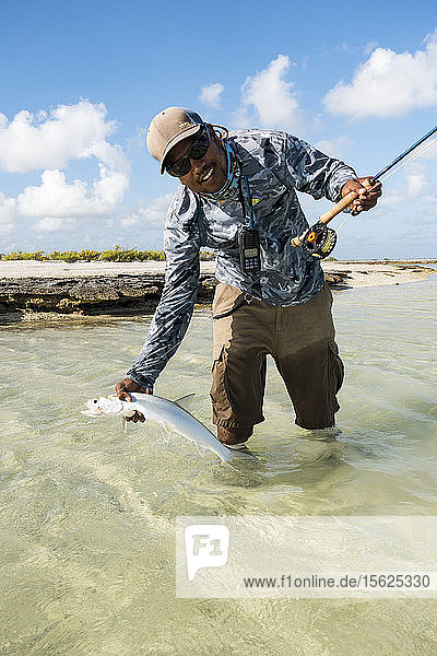 Fisherman releasing bonefish caught on Kiribati Atoll