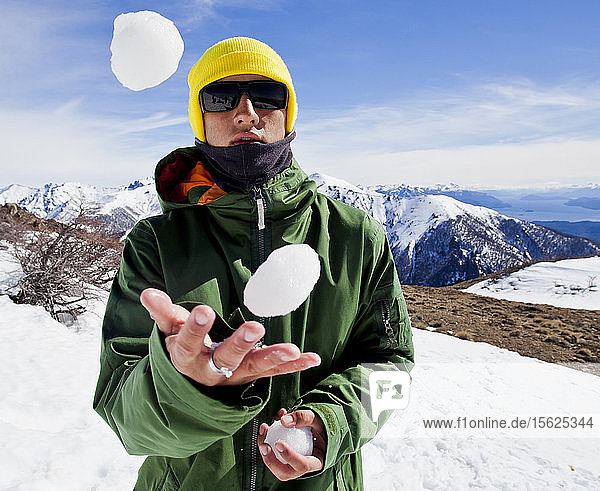 Ein Snowboarder jongliert Schneebälle an einem sonnigen Tag am Cerro Catedral in Argentinien