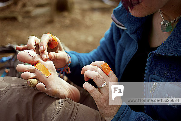 Eine Wanderin auf dem Appalachian Trail verbindet eine Reihe von Blasen an ihren Füßen. Oft wird Klebeband anstelle der eigentlichen medizinischen Versorgung verwendet.