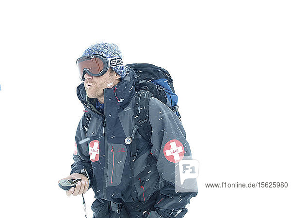 Ein norwegischer Bergführer navigiert in einem Schneesturm mit einem tragbaren GPS-Gerät.