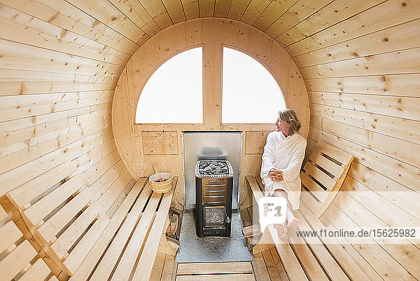 Eine Frau entspannt sich in der hölzernen Sauna der Lagazuoi-Hütte in den Dolomiten  Italien