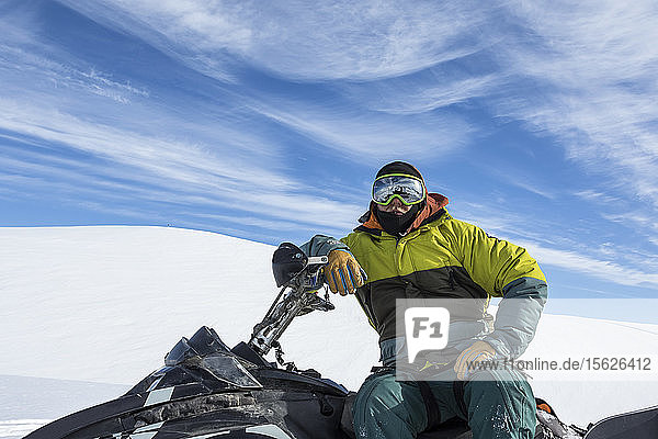 Porträt eines Mannes auf einem Schneemobil im Norden von British Columbia