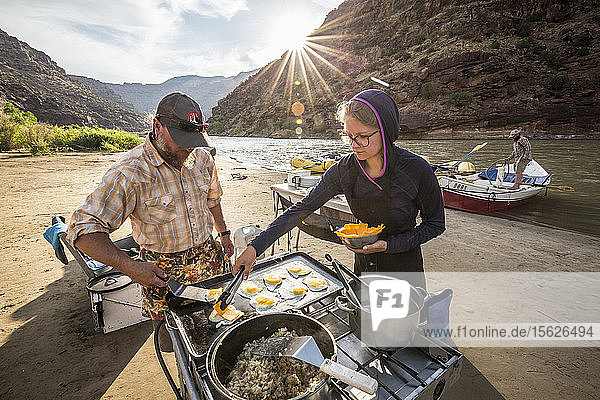 Two rafting guides cooking a meal at camp while on a Green river rafting trip  ï¾ Desolation/Grayï¾ Canyon section  Utah  USA