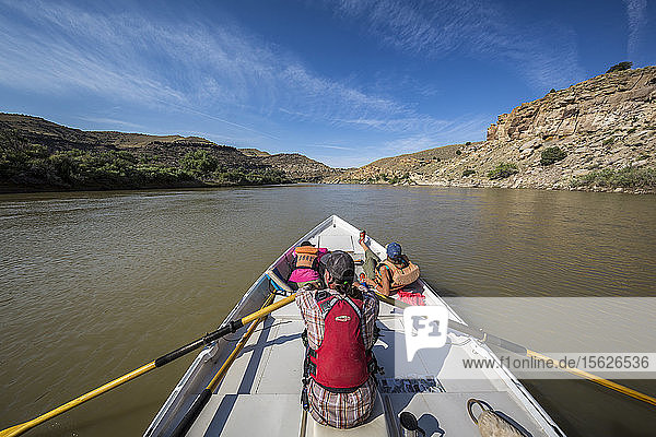 Man and two women sailing across calm Green River in Desolation Canyon  Utah  USA