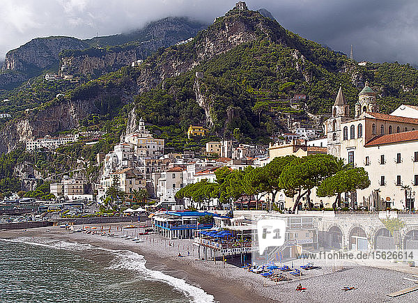 Die an der Bucht von Salerno gelegene Klippenstadt Amalfi verfügt über eine beliebte Strandpromenade. Amalfi ist eine Stadt und Gemeinde in der Provinz Salerno  in der Region Kampanien  Italien  am Golf von Salerno. Sie liegt an der Mündung einer tiefen Schlucht  am Fuße des Monte Cerreto (1.315 Meter)  umgeben von dramatischen Klippen und Küstenlandschaften. Die Stadt Amalfi war die Hauptstadt der Seerepublik Herzogtum Amalfi  einer wichtigen Handelsmacht im Mittelmeerraum zwischen 839 und etwa 1200. In den 1920er und 1930er Jahren war Amalfi ein beliebtes Urlaubsziel für die britische Oberschicht und Aristokratie. Amalfi ist der Hauptort der Küste  die Costiera Amalfitana (Amalfiküste) genannt wird  und ist heute zusammen mit anderen Orten an derselben Küste wie Positano  Ravello und anderen ein wichtiges Touristenziel. Amalfi ist Teil des UNESCO-Weltkulturerbes.