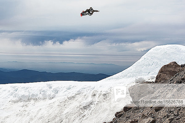 Ein Snowboarder springt im Sommer von einer großen Schanze am Mt. Hood