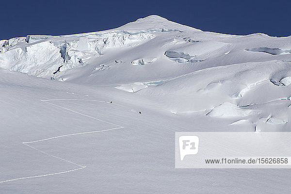 Bergsteiger fahren auf 12.000 Fuß Höhe am Denali in Alaska einen Hang hinunter.