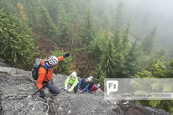 Eine Gruppe von Leuten genießt eine Via Ferrata an einem regnerischen Herbsttag in Squamish  British Columbia.