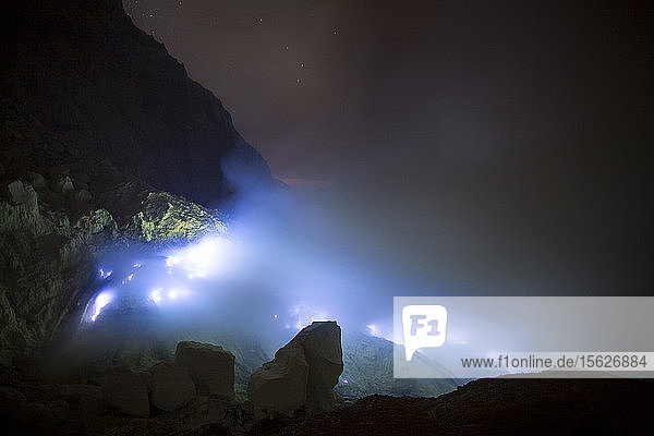 Blaue Flammen aus geschmolzenem Schwefel brennen in der Mine im Krater des Vulkans Kawah Ijen  Banyuwangi  Java  Indonesien