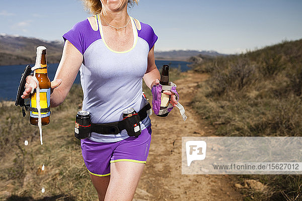 Nahaufnahme einer sportlichen Frau  die mit Sitzungsbieren zur Hydratation läuft
