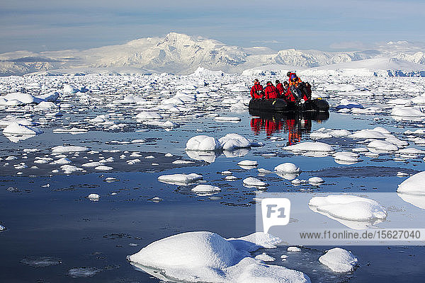 Members of an expedition cruise to Antarctica in a Zodiak in Fournier Bay in the Gerlache Strait on the Antarctic peninsula. The Antarctic peninsula is one of the most rapidly warming areas on the planet.